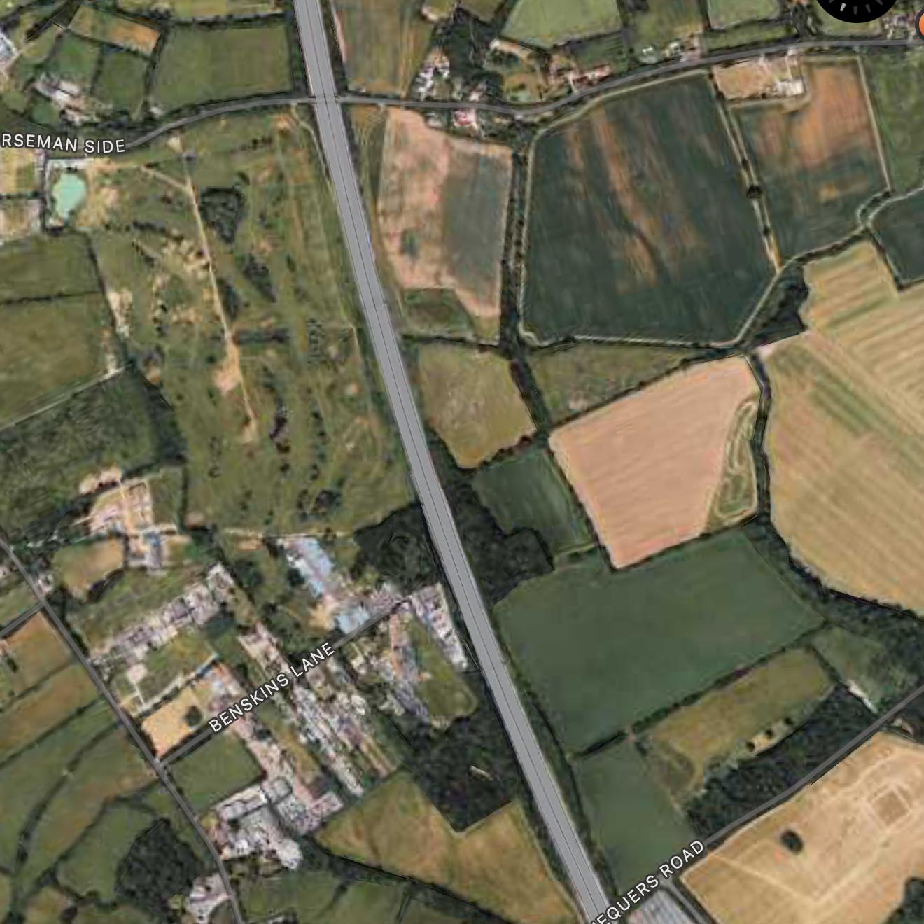 Aerial view of the M25 between Horseman Side and Chequers Road, with open fields on both sides